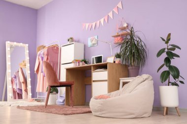 Çalışma odası, ayna ve elbise askısı olan şık bir gencin odası.