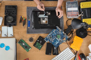 Servis merkezinde dizüstü bilgisayar tamir eden erkek teknisyen, üst görünüm