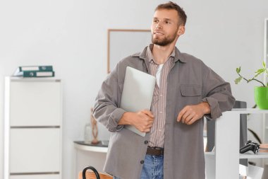 Dizüstü bilgisayarı olan genç sakallı programcı.