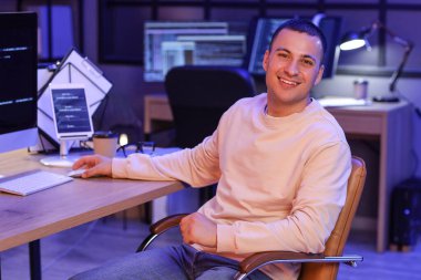 Geceleri bilgisayarla çalışan yakışıklı bir programcı.