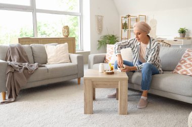 Kemoterapiden sonra evde ot öğüten olgun bir kadın.