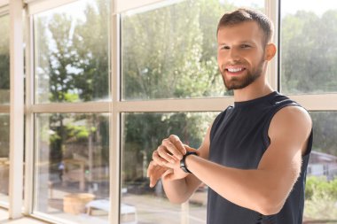 Akıllı, genç bir adam pencerenin yanındaki nabzını kontrol ediyor.