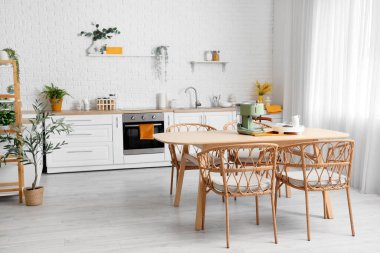 Yemek masasında modern kahve makinesi olan hafif mutfağın içi.