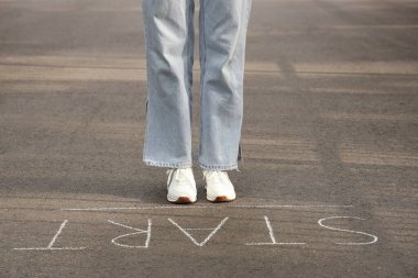 Sözcüklerle asfalt yolda duran bir kadın. Yeni başlangıç kavramı