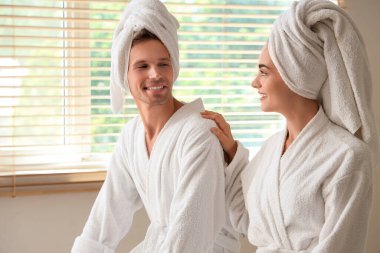 Banyodan çıktıktan sonra havluları olan genç çift.