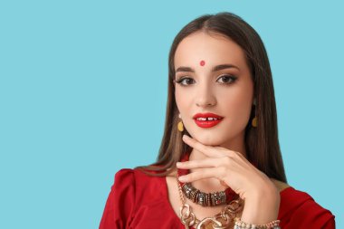 Mavi arka planda şık sarili güzel Hintli kadın.