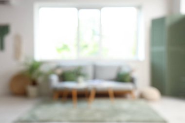 Kanepesi, masası ve penceresi olan oturma odasının bulanık görüntüsü