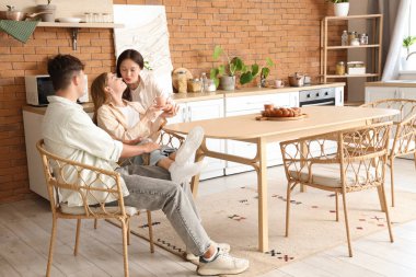 Mutfakta iki kadınla öpüşen genç adam. Poliyamory konsepti