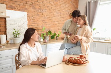 İki kadınla birlikte mutfakta vakit geçiren genç bir adam. Poliyamory konsepti