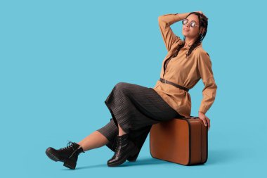 Zarif Afro-Amerikan kadın rastalı ve mavi arka planda çanta