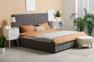 Şık bir yatak odası, büyük yatak odası, masa ve puf.