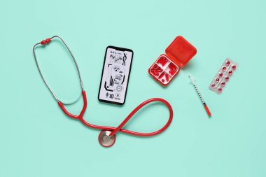 Yeşil arka planda cep telefonu ve tıbbi malzemeler. Teletıp kavramı