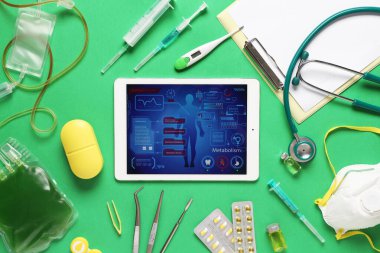 Tablet bilgisayar ve tıbbi malzemeler yeşil arka planda. Teletıp kavramı