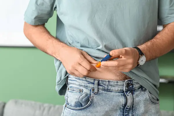 stock image Diabetic young man using lancet pen at home, closeup