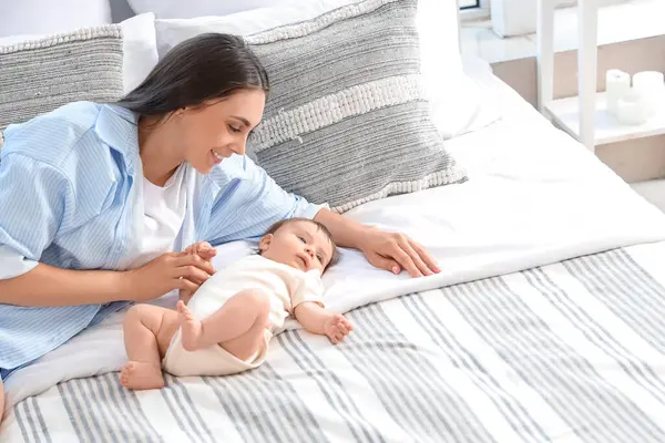 Anne ve küçük bebeği yatak odasında yatıyor.