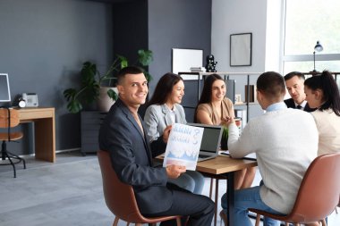 Konferans salonundaki masada pazarlık yapan iş adamları