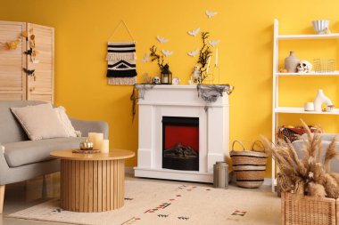 Cadılar Bayramı için şömine ve kanepeyle dekore edilmiş oturma odasının içi.