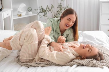 Genç lezbiyen çift yatak odasında eğleniyor.