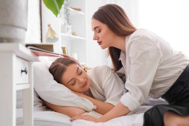 Yatak odasında uyuyan karısı olan genç lezbiyen kadın.