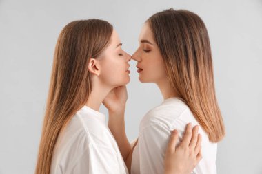 Genç lezbiyen çift arka planda burunlarına dokunuyor, yakın plan.