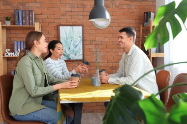 Kafedeki masada kahve içen gençler