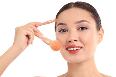 Beyaz arka planda makyaj fırçası olan genç Asyalı kadın, yakın plan.