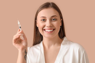 Bej arka planda enjeksiyonu olan güzel genç kadın, yakın plan.