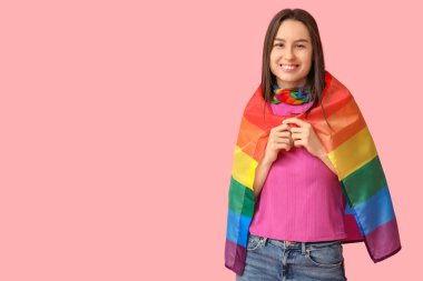 Pembe arka planda LGBT bayrağı olan güzel genç bir kadın.
