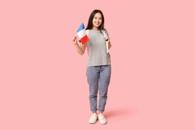 Pembe arka planda Fransız bayrağı olan bir kız öğrenci.