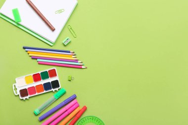 Yeşil arka planda kalemler ve keçeli kalemler. Üst görünüm