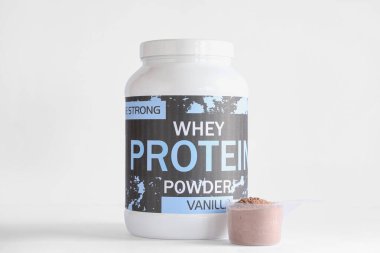 Hafif arka planda protein tozuyla şişe ve kepçe