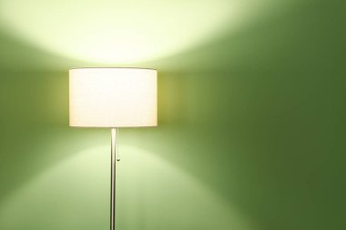 Yeşil arkaplanda parlayan zemin lambası, yakın plan