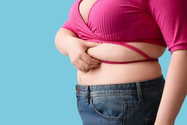 Mavi arka planda şişman bir kadın, yakın plan. Diyet kavramı