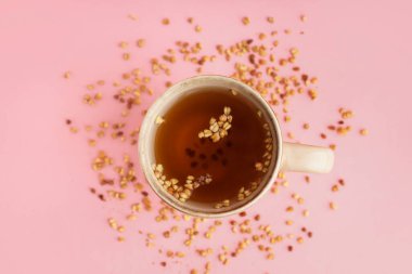 Pembe arka planda bir fincan lezzetli karabuğday çayı