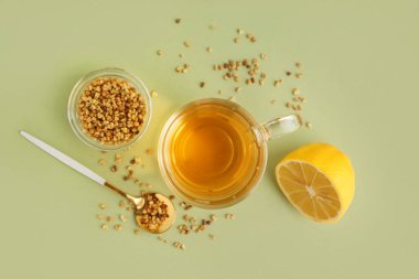 Yeşil arka planda bir bardak lezzetli karabuğday çayı ve limon.