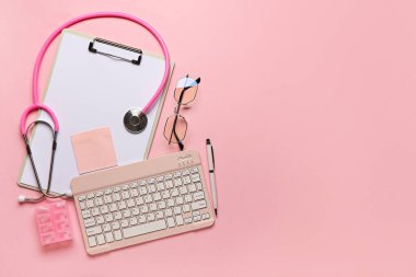 Pembe arka planda gözlük, dosya, bilgisayar klavyesi ve steteskop.