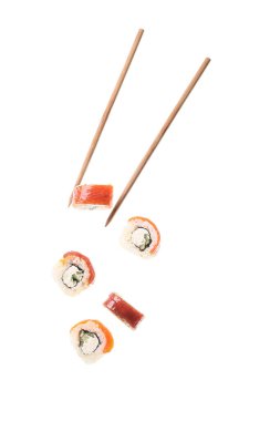 Beyaz arka planda lezzetli uçan suşi ruloları ve çubuklar.