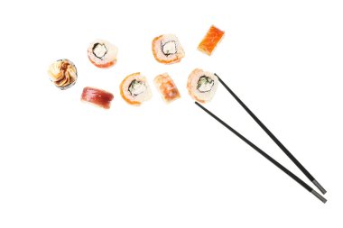 Beyaz arka planda lezzetli uçan suşi ruloları ve çubuklar.