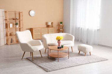 Oturma odası, kanepe, koltuk ve nergis çiçekleri.