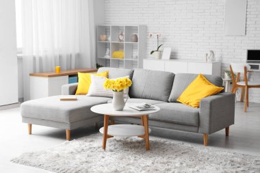 Oturma odasındaki kahve masasındaki sürahide nergis çiçeği