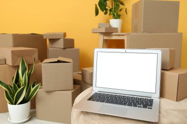 Boş dizüstü bilgisayar pouf 'ta, kutuları odada taşıyor, yakın plan.