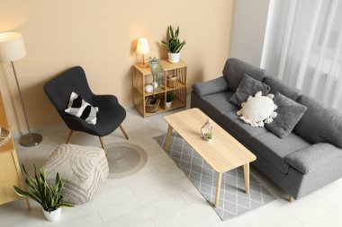 Oturma odasının içinde kanepe, koltuk ve parlak lambalar var.