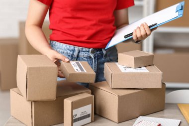 Posta deposunda pano ve paket kutuları olan kadın işçi, yakın plan.