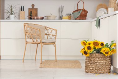 Koltuklu, tezgahlı ve sepetli aydınlık mutfağın içi.