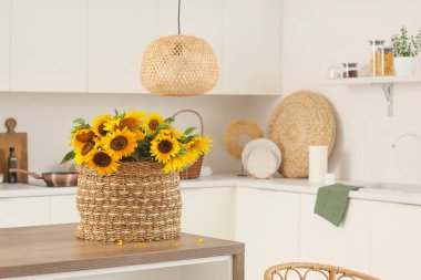 Açık mutfakta yemek masasında ayçiçekli sepet.