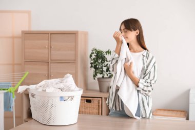 Çamaşır odasında temiz havlusu olan genç bir kadın.