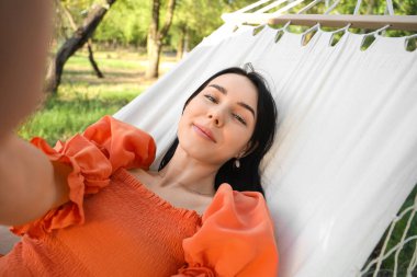 Hamakta selfie çeken genç bir kadın, yakın plan.