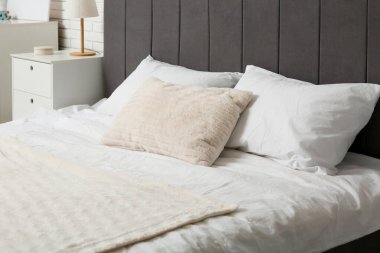 Yatak odasında beyaz yastıklı büyük bir yatak.