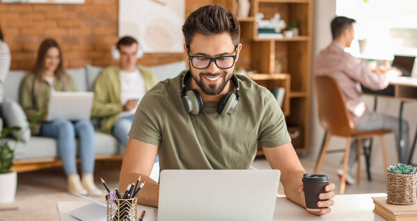 Студент с ноутбуком в университете