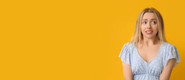 Sarı arka planda utanmış genç bir kadın ve mesaj için yeri var.